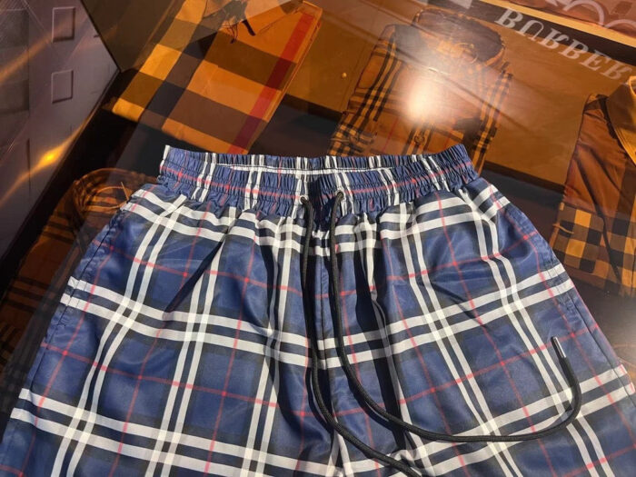 Pantaloncini a quadri con cintura elastica e dettagli metallici, ideali per relax e attività allaperto.