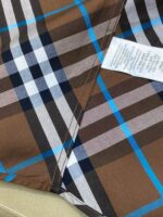 Tessuto a quadri marrone, blu e bianco in cotone per abbigliamento casual.