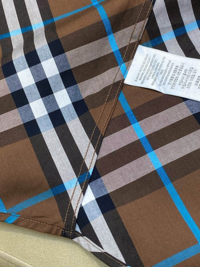 Tessuto a quadri marrone, blu e bianco in cotone per abbigliamento casual.