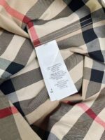 Tessuto a quadri elegante con etichetta di cura, stile classico e alta qualità.