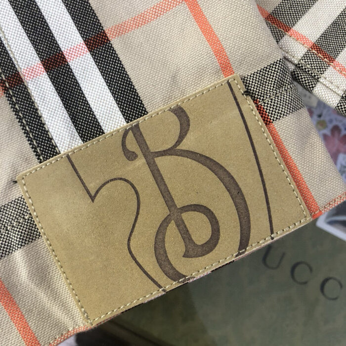 Tessuto plaid di lusso con logo Gucci, dettagli eleganti e qualità artigianale.