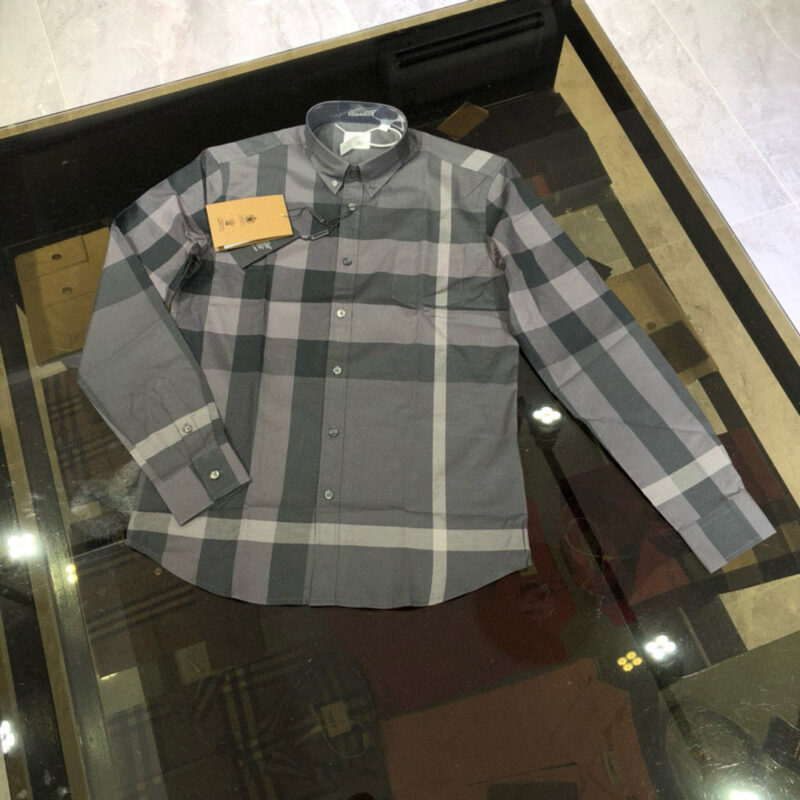 Camicia a quadri grigia classica su tavolo riflettente, stile casual ed elegante.