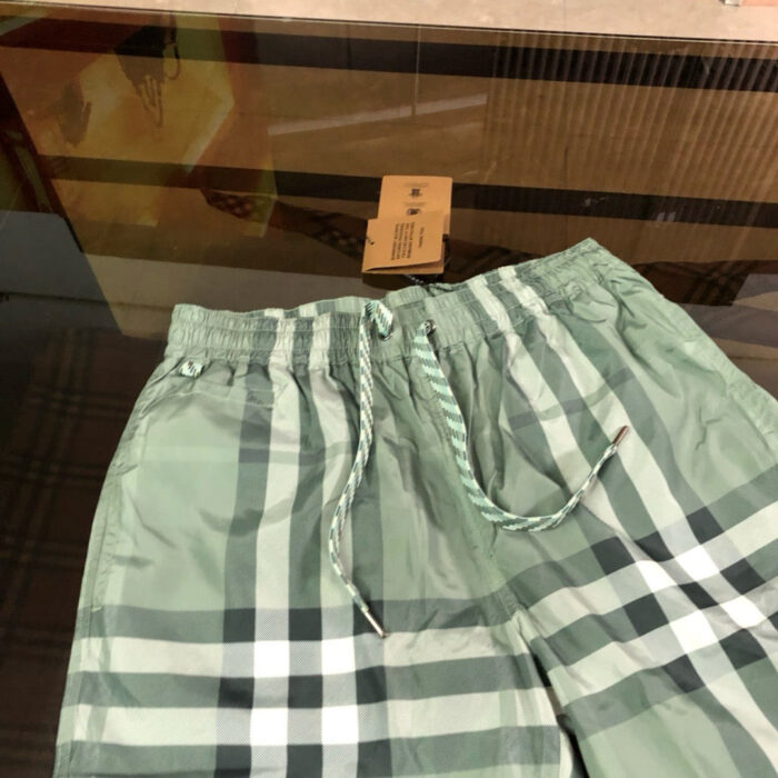 Pantaloncini estivi verdi a quadri con coulisse e tag, perfetti per casual e spiaggia.