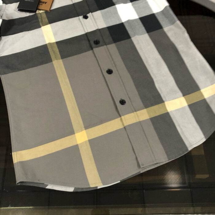Camicia moderna a quadri grigia con dettagli gialli per uno stile elegante e versatile.