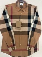 Camicia a quadri in toni terra, maniche lunghe, bottoni dorati e colletto strutturato.