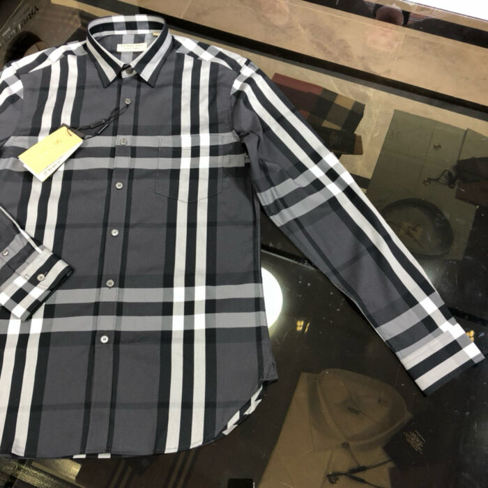 Camicia uomo a quadri moderna a manica lunga su superficie riflettente, stile casual e elegante.