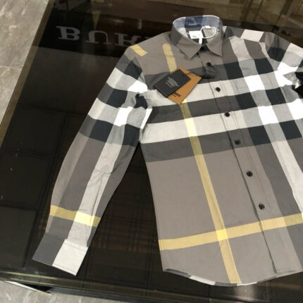 Camicia a quadri moderna, maniche lunghe, stile casual e elegante su superficie riflettente nera.