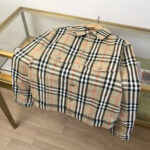 Camicia plaid di lusso oversize su tavolo in vetro, stile elegante e raffinato.
