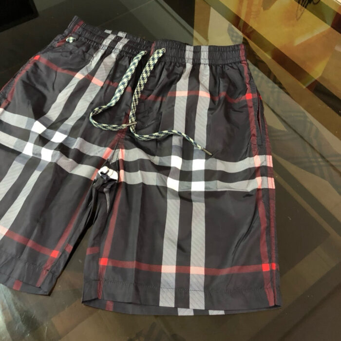 Shorts da spiaggia con quadri rossi, neri e bianchi, elastico e tasche per l’estate.