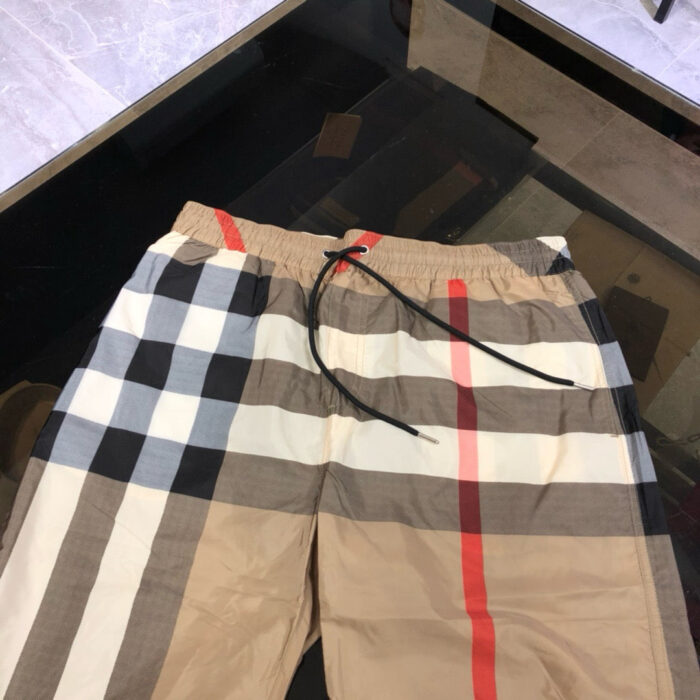 Shorts casual in tessuto plaid beige e marrone, con cordino nero e stile classico e versatile.