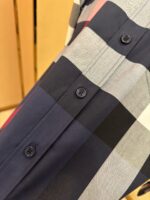 Camicia a quadri blu, grigio e nero con bottoni e dettagli di alta qualità.