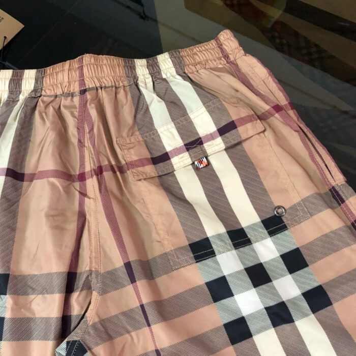 Pantaloncini da spiaggia in tartan con cintura elastica e tasca posteriore, stile casual estivo.