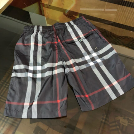 Costume da bagno checkered in toni scuri con dettagli rossi, stile sporty e moderno.