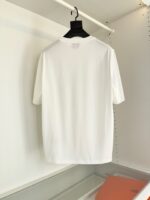 T-shirt bianca classica su gruccia nera, look minimalista, comfort e stile casual per ogni occasione.