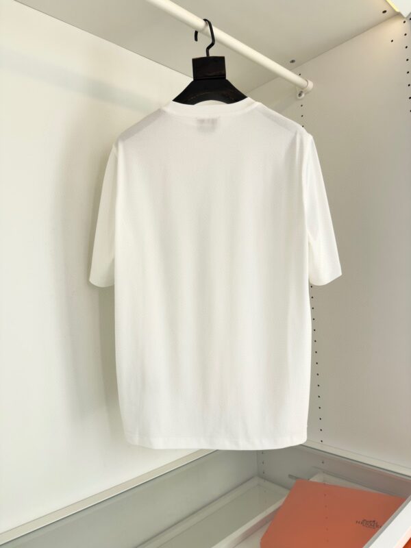T-shirt bianca classica su gruccia nera, look minimalista, comfort e stile casual per ogni occasione.