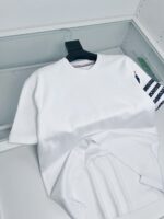 Maglietta bianca con manica a righe nautica, stile casual e moderno.