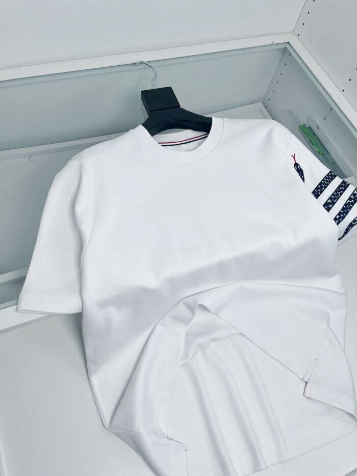 Maglietta bianca con manica a righe nautica, stile casual e moderno.