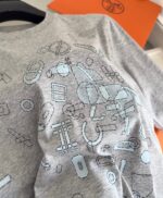 T-shirt grigia con stampa astratta blu, design giocoso e moderno per uno stile casual creativo.
