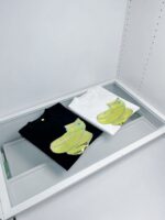 Magliette con banane in bianco e nero in vetrina minimalista per uno stile moderno e giocoso.