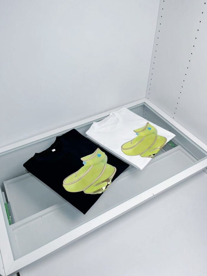 Magliette con banane in bianco e nero in vetrina minimalista per uno stile moderno e giocoso.
