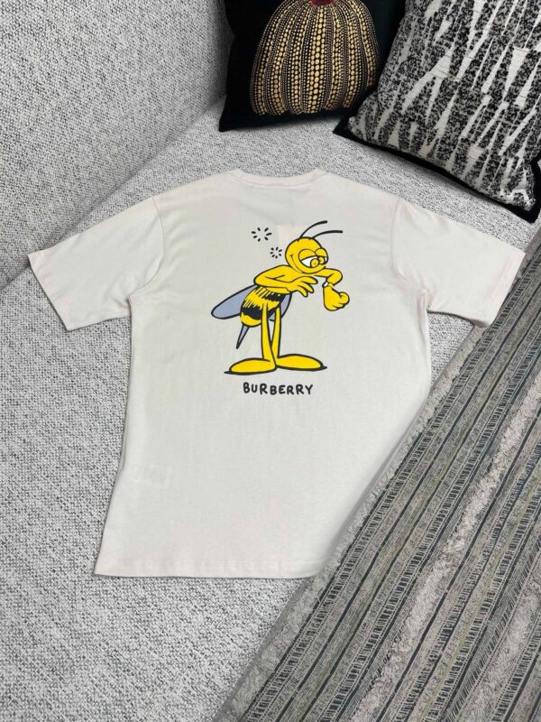 Maglietta beige con ape cartoon e logo Burberry, stile umoristico e casual, ideale per il divertimento.