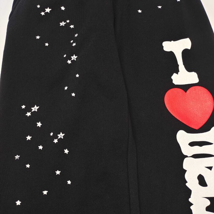 Pantaloni neri casual con cuore rosso e stelle bianche, stile giovane e giocoso.