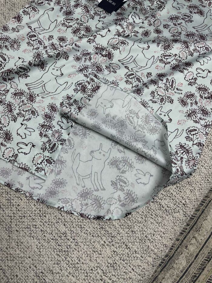 Tessuto colorato con cani stilizzati e fiori, ideale per abbigliamento casual e accessori.