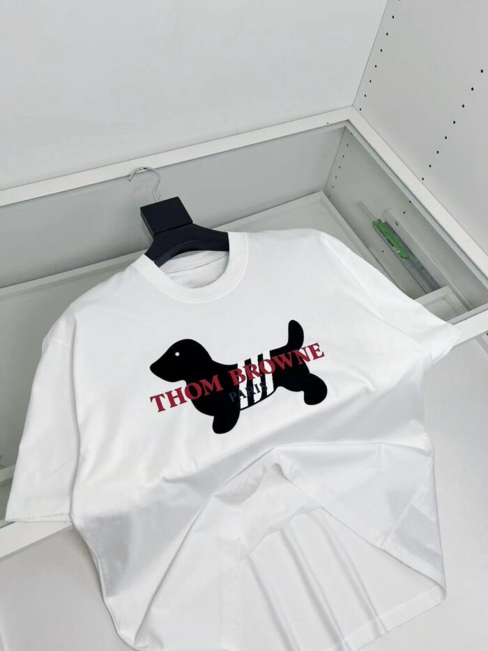 T-shirt bianca con cane stilizzato nero e logo rosso THOM MAWNE in stile streetwear.