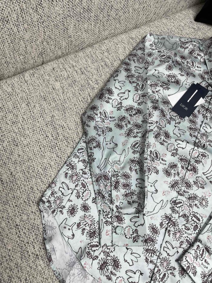 Camicia estiva con motivo floreale e gatti stilizzati, ideale per look casual e originale.