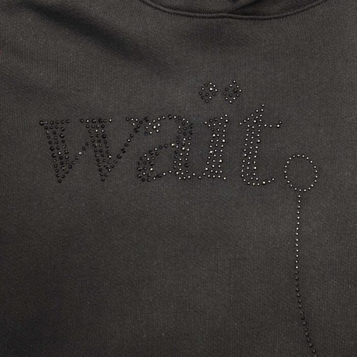 Felpa con scritta wait in strass nero, stile casual e glamour, perfetta per look streetwear.
