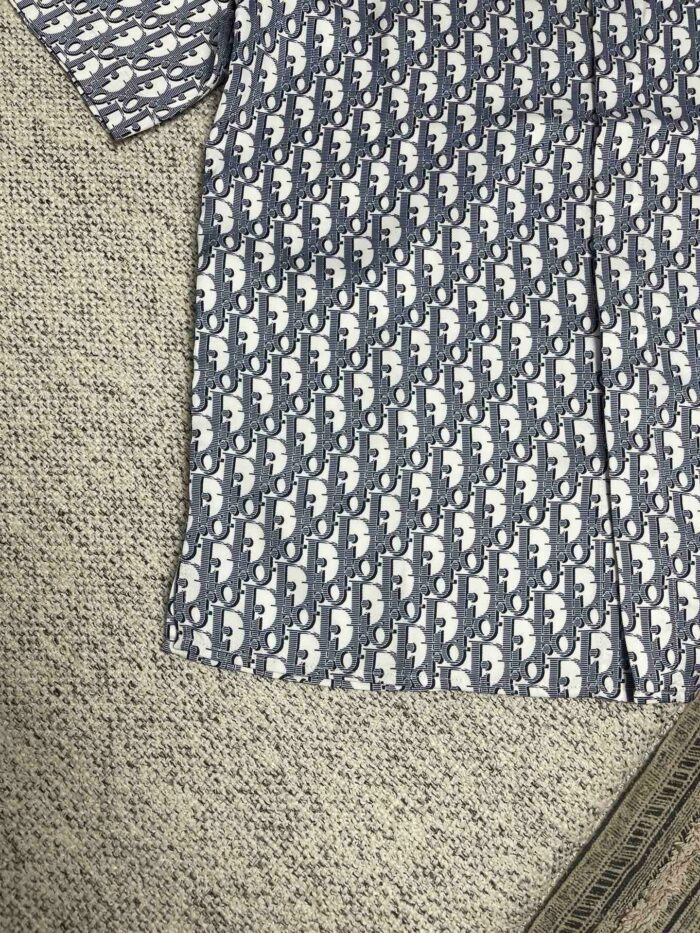 Camicia estiva in cotone con fantasia di animali stilizzati azzurri e bianchi, casual e fresca.