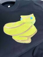 Felpa nera con grafica di scarpa verde giocosa e colorata, stile streetwear originale e vivace.