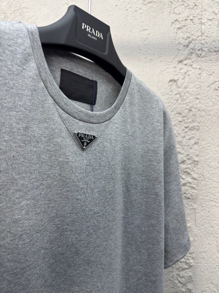 T-shirt grigia Prada con logo triangolare, stile casual ed elegante, morbida e versatile.