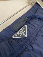 Pantaloni Prada Navy con logo in metallo e dettagli di lusso raffinato.