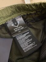 Etichetta Prada Re-Nylon sostenibile su tessuto verde elegante, alta moda e materiali riciclati.