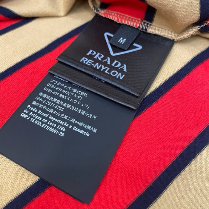 Giacca Prada Re-Nylon a strisce, sostenibile ed elegante, con etichetta di alta moda italiana.