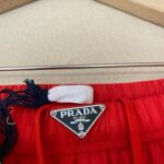 Pantaloncini Prada rossi con logo, coulisse navy e tessuto casual estivo.