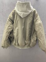 Giaccone oversize imbottito neutro con cappuccio e toni eleganti, perfetto per linverno urbano.