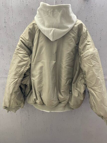 Giaccone oversize imbottito neutro con cappuccio e toni eleganti, perfetto per linverno urbano.
