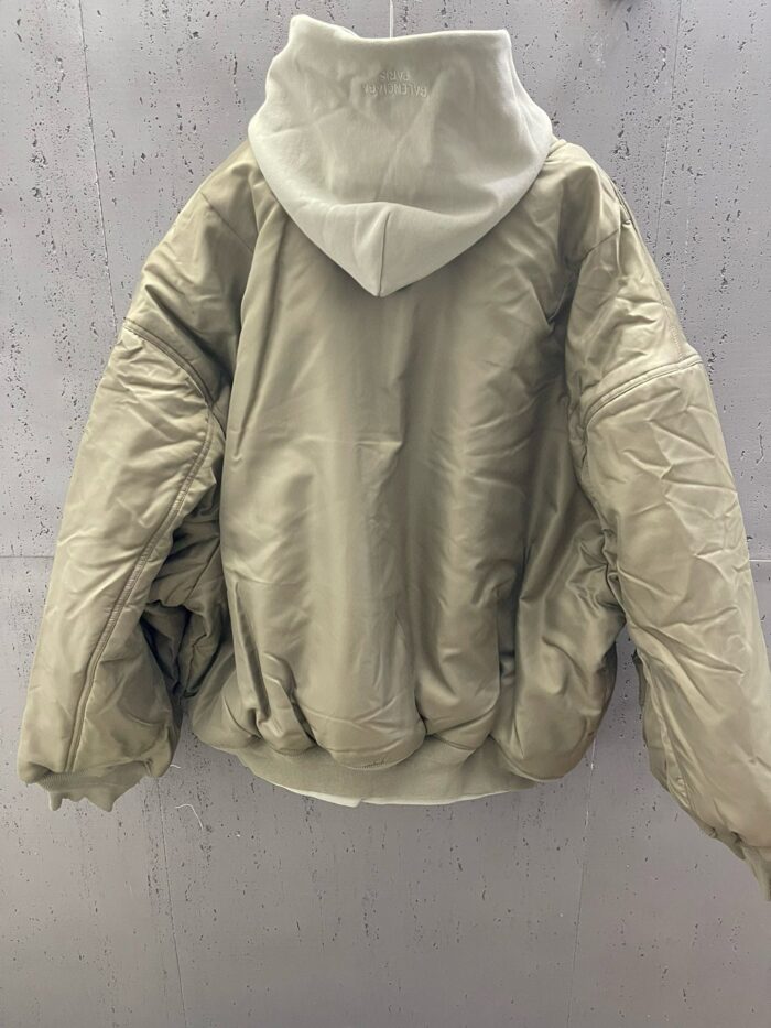 Giaccone oversize imbottito neutro con cappuccio e toni eleganti, perfetto per linverno urbano.