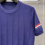 Camicia viola con dettagli sportivi a strisce rosso, bianco e blu sulla manica.