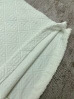 Coperta in tessuto bianco con motivo a rombi e bordo ricamato, alta qualità italiana.