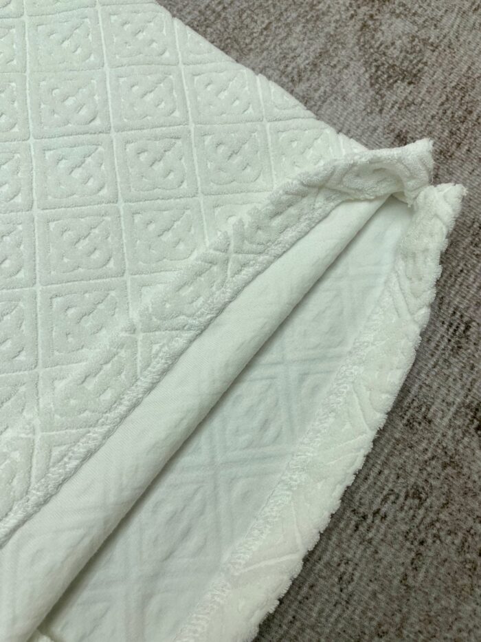 Coperta in tessuto bianco con motivo a rombi e bordo ricamato, alta qualità italiana.
