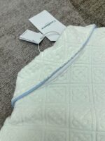 Plaid bianco con motivi floreali e bordi azzurri, tessuto caldo e decorativo, ideale per la casa.