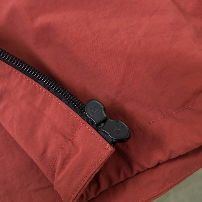 Giacca moderna con zip in metallo e tessuto lucido color caldo rosso-marrone.