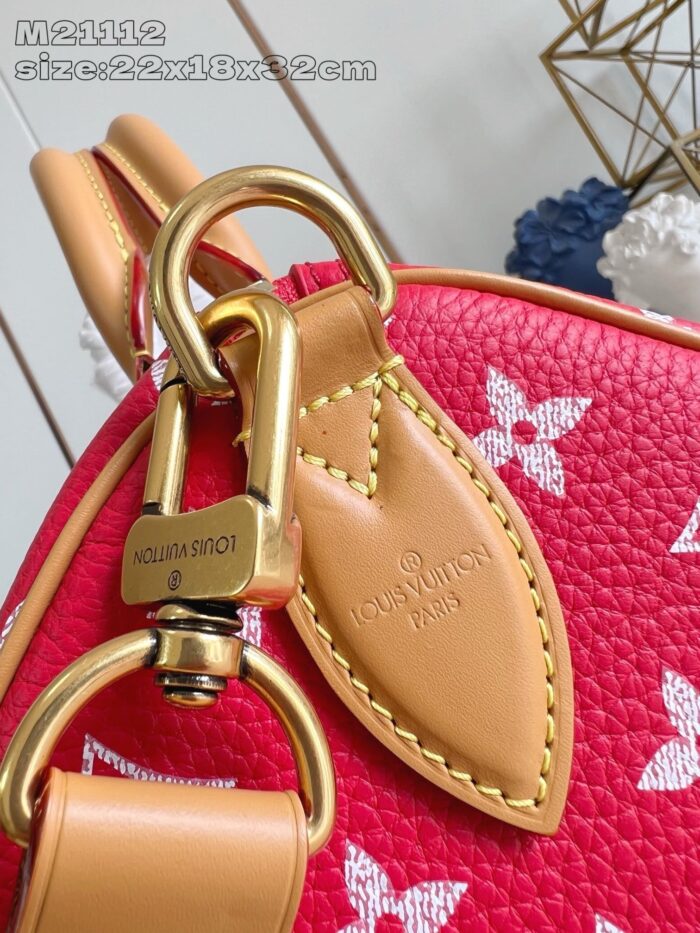 Borsa in pelle rossa con motivi bianchi e hardware dorato raffinato.