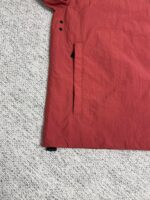 Giacca rossa impermeabile con tasca nascosta e cuciture resistenti, stile moderno e pratico.