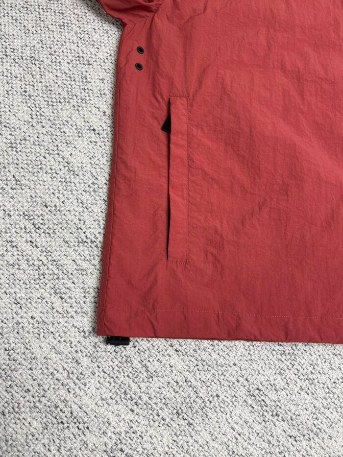 Giacca rossa impermeabile con tasca nascosta e cuciture resistenti, stile moderno e pratico.