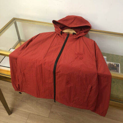 Giaccone rosso leggero con cappuccio, tasche e zip, stile outdoor e moda urbana.