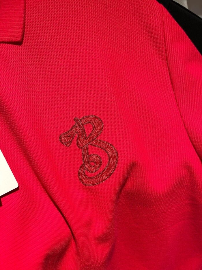 Maglietta polo rossa con ricamo elegante della lettera B, tessuto morbido e stile versatile.